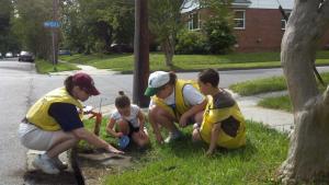 Storm Drain Medallions were placed on drains in Suburban Park and Wards Corner in May 2012 by (from left) Marsha Lockard, Cecilia Fox, C.J. Lockard, and Sebastian Fox.  