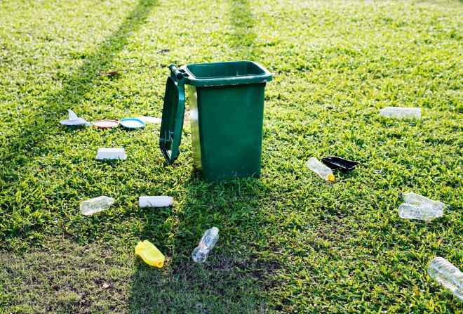 green trash bin on green grass field